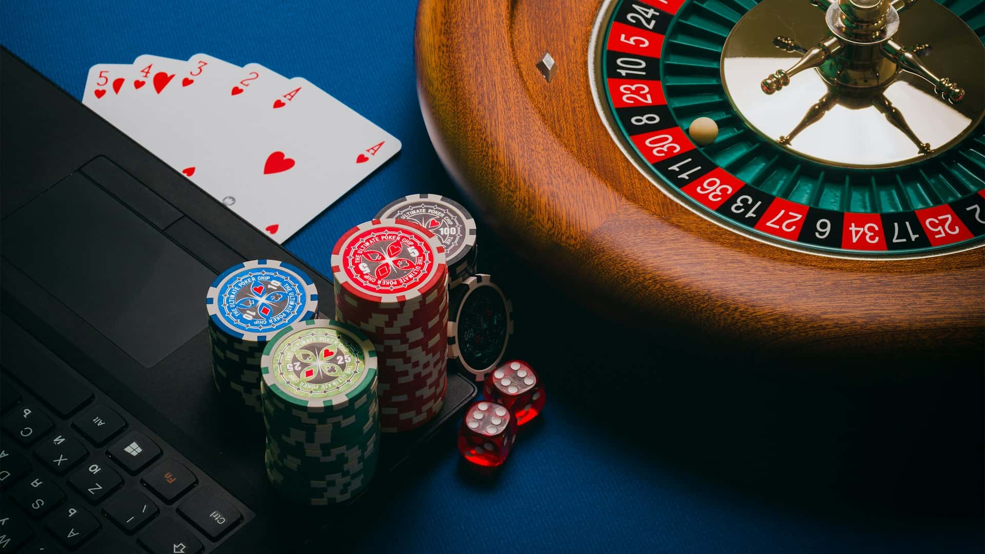 Playing cards and poker chips casually arranged on a felt table.